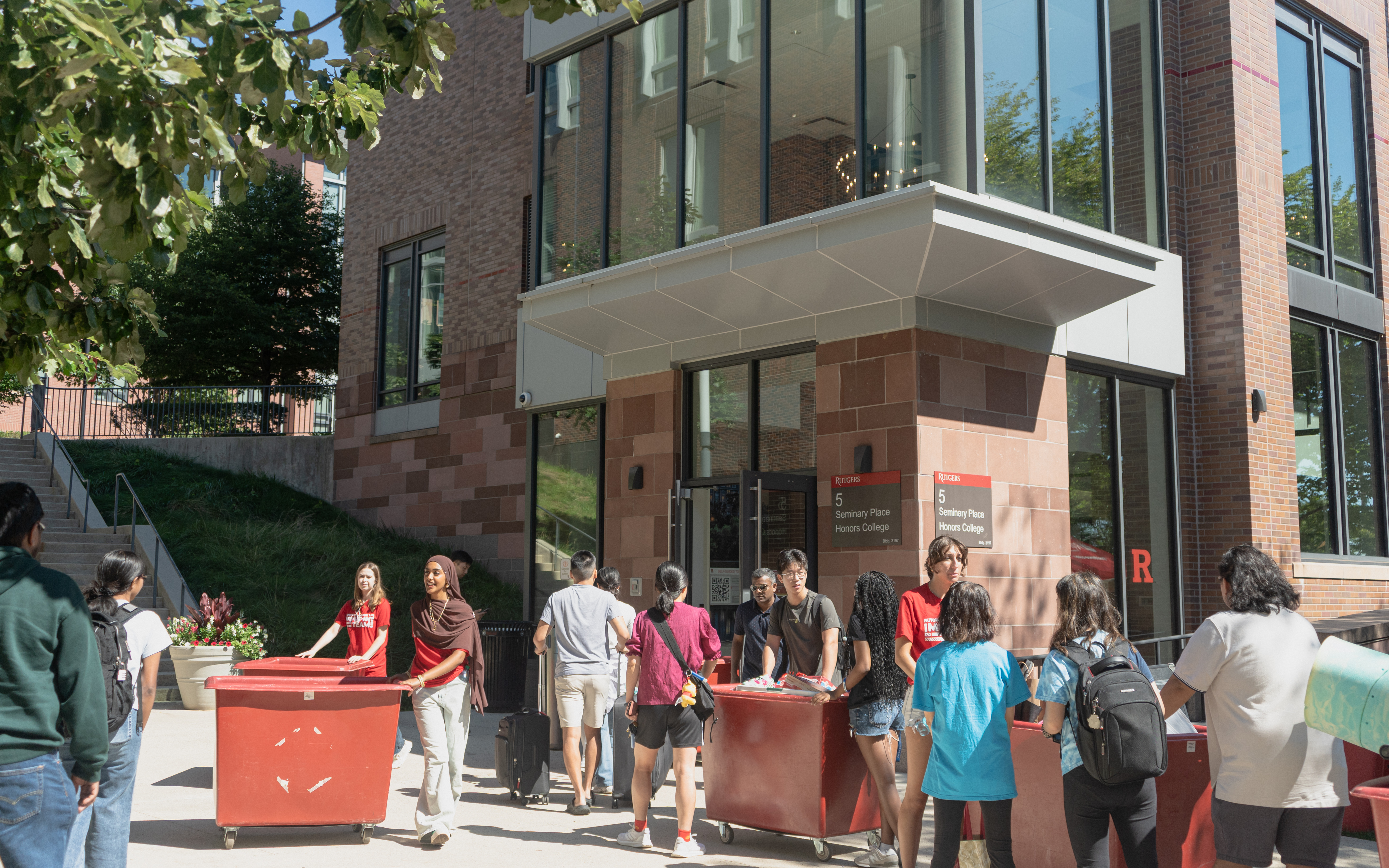 In picture, Honors College volunteers assist movers with transporting items outside of the Rutgers Honors College HQ