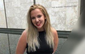 Grace outside of a building with a reflecting pool behind her