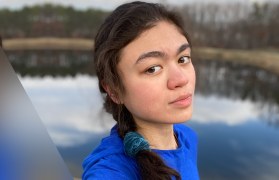 Photo of Michaela outside with water in the background.